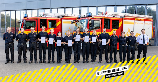 Gruppenbild Die Lehrgangsteilnehmer zeigen ihre Urkunde bei einer Gruppenaufnahme vor einem Löschfahrzeug