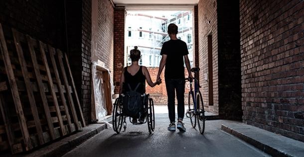 Liebe Kennt keine Barrieren (Foto: Weiland) Eine junge Frau im Rollstuhl und ein junger Mann mit einem Fahrrad halten Hände. Der Mann schiebt ein Fahrrad (Foto: Weiland)