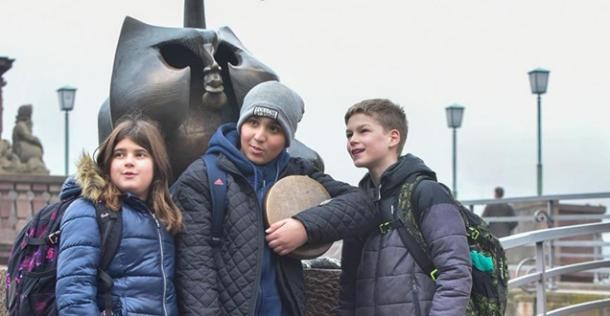 Drei Schulkinder vor dem Heidelberger Brückenaffen (Foto: Dorn) Drei Schulkinder vor dem Heidelberger Brückenaffen