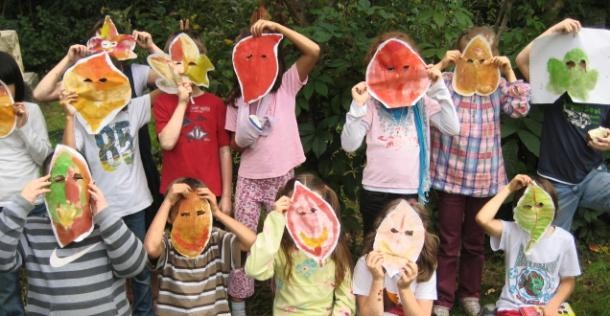Kindergruppe mit Blättermasken (Foto: Gustave Krieg) Kindergruppe mit Blättermasken.