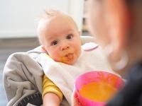 Gruppenangebote und Beratung gibt es für Eltern mit Babys im Familienbüro der Stadt Heidelberg. (Foto: Stephany) Ein Baby wird mit Brei gefüttert und streckt die Zunge zur Kamera aus.