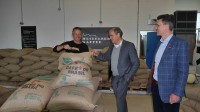 Oberbürgermeister Prof. Dr. Eckart Würzner (M.) und Marc Massoth (r.) vom Amt für Wirtschaftsförderung und Wissenschaft besuchten die Kaffeerösterei KAPLINIO. (Foto: Stadt Heidelberg) Oberbürgermeister Prof. Dr. Eckart Würzner (M.) und Marc Massoth (r.) vom Amt für Wirtschaftsförderung und Wissenschaft lassen sich von einem weiteren Mann einen Sack Kaffee zeigen.