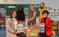 Präsentieren die Materialien der neuen Sprachkoffer-Sets (v.l.): Anja Schmidt, Rektorin der Albert-Schweitzer-Schule, Schulamtsdirektorin Florence Brokowski-Shekete, Isabel Arendt und Franz Meißner vom Amt für Schule und Bildung sowie Bürgermeisterin Stefanie Jansen. (Foto: Peter Dorn) Gruppenbild mit Bürgermeisterin Jansen in einem Klassenzimmer.