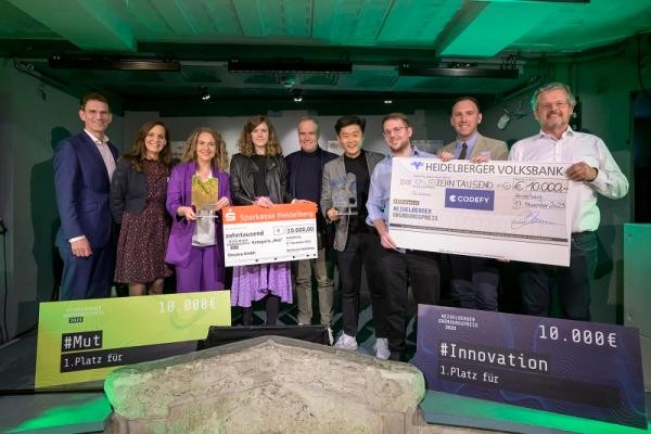 Die Preisverleihung 2023. (Foto: Rothe) Gruppenbild. Fünf Personen halten insgesamt zwei Schecks hoch.
