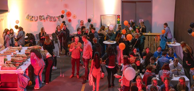 Junge Menschen stehen abends bei einer Party mit Luftballons.