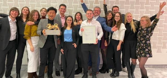 Eine Gruppe von Menschen posiert für ein Foto, ein Teil von ihnen jubelt.