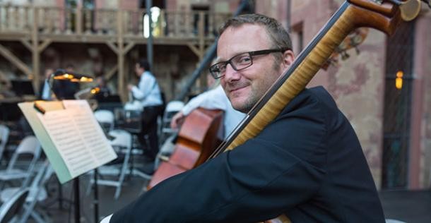 Orchestermusiker. (Foto: Diemer) Kontrabassist blickt über die Schulter in die Kamera.