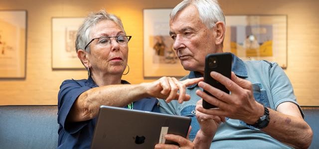 Zwei ältere Menschen mit Handy und Tablet