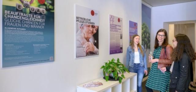 Zwei Besucherinnen vor einem Plakat