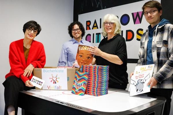 Wollen Literatur zu queeren Themen für pädagogische Fachkräfte sowie für Kinder und Jugendliche zugänglich machen (v.l.): Bürgermeisterin Stefanie Jansen, Marius Emmerich von der städtischen Koordinationsstelle LSBTIQ+ sowie Sigrid Laber und Oliver Netzel von der Fachstelle „Rainbow City Kids“. (Foto: Mechthild Stein) Vier Personen bei der Buchvorstellung von Literatur zu queeren Themen.