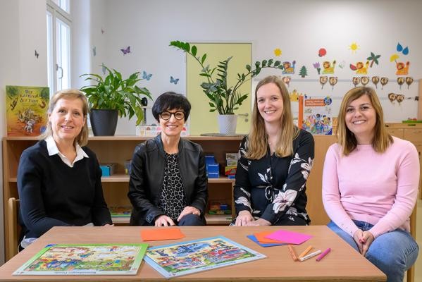 In der Kita Paradeplatz und in den anderen 23 städtischen Kindertagesstätten hat das Kinder- und Jugendamt sich auf Personalausfälle im Herbst und Winter gut vorbereitet (v.l.): Susanne Engelhardt-Feil (Kinder- und Jugendamt), Bürgermeisterin Stefanie Jansen, Justine Hintenlang (Kinder- und Jugendamt), Zekiye Dursun (Leitung Kita Paradeplatz). (Foto: Rothe) Vier Frauen sitzen im Kindergarten auf kleinen Stühlen und lächeln in die Kamera.