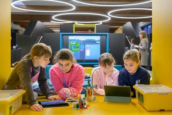 Lernen neu gedacht: Im zentral gelegenen digitalen Zentrum der Waldparkschule, dem sogenannten „Fuchsbau“, können Schülerinnen und Schüler jahrgangs- und klassenübergreifend an Projekten arbeiten und dabei digitale Hilfsmittel nutzen. (Foto: Rothe) Vier Kinder lernen mit digitalen Medien.