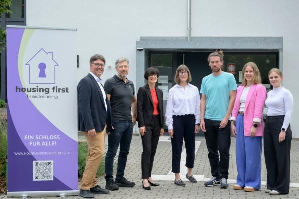 Freuen sich über erste Erfolge beim Projekt „Housing First“ für wohnungs- und obdachlose Menschen (v.l.): Dr. Michael Wolff (Ministerium für Soziales, Gesundheit und Integration des Landes Baden-Württemberg), Matthias Meder (SKM), Bürgermeisterin Stefanie Jansen, Heidi Farrenkopf (Evangelische Stadtmission) und das Housing-First-Team Thomas Prestel, Lea Schwab und Mona Keitel. (Foto: Philipp Rothe) Dr. Michael Wolff, Matthias Meder, Bürgermeisterin Stefanie Jansen, Heidi Farrenkopf und das Housing-First-Team Thomas Prestel, Lea Schwab und Mona Keitel stehen vor dem Projektbüro von Housing First im Karl-Klotz-Haus .