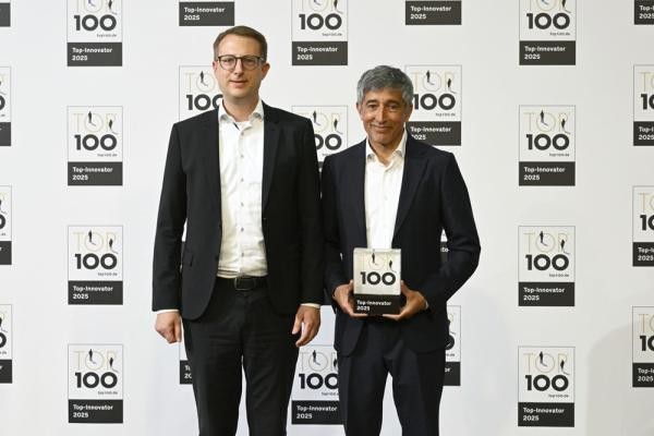 Ranga Yogeshwar übergibt den TOP 100 Award an Andreas Zühlcke, Vice President Product Management und Marketing bei ProMinent (Bild: KD Busch / compamedia).  Zwei Männer stehen vor der Kamera. Einer von ihnen hält eine Skulptur, auf der eine 100 zu sehen ist.