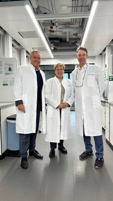 Einblick in die Labore im BioLabs auf dem Heidelberg Innovation Park (hip): Nicole Razavi, Ministerin für Landesentwicklung und Wohnen Baden-Württemberg, gemeinsam mit Oberbürgermeister Eckart Würzner (links) und Johannes Fruehauf, Gründer und Präsident BioLabs. Zwei Männer und eine Frau in Laborkitteln in einem Biolabor