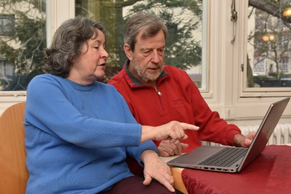 Bei der „Eingeloggt!“-Aktionswoche im März 2026 können ältere Menschen die digitale Welt besser kennenlernen. Wer sich mit Angeboten beteiligen möchte, kann sich bis 15. November anmelden. (Foto: Peter Dorn) Zwei ältere Menschen (eine Frau in blauem Pulli und ein mann in rotem Pulli) sitzen mit einem Laptop an einem Tisch. Die Frau zeigt mit ihrem Finger auf den Bildschirm, beide schauen in die Richtung des Bildschirmes.