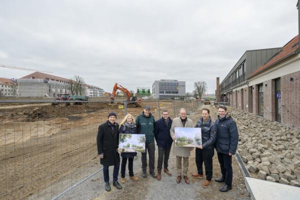 Freude über den Start der Arbeiten an den Freiflächen im Heidelberg Innovation Park (hip): Im Hin-tergrund haben die Bauarbeiten am zentralen Mary-Somerville-Platz begonnen. Über den Baustart und die Herstellung der Grün- und Freiflächen im hip informierten vor Ort (v.l.n.r.) Volker Schwarz, Andrea Krastel, Dr. Ernst Baader (alle Landschafts- und Forstamt), Umweltbürgermeister Raoul Schmidt-Lamontain, Oberbürgermeister Eckart Würzner, Götz Gramlich (Gesellschafter Tdrei, Entwickler Stallungen), sowie Marc Massoth (Amt für Wirtschaftsförderung). Eine Gruppe von Personen steht vor einer Baustelle.