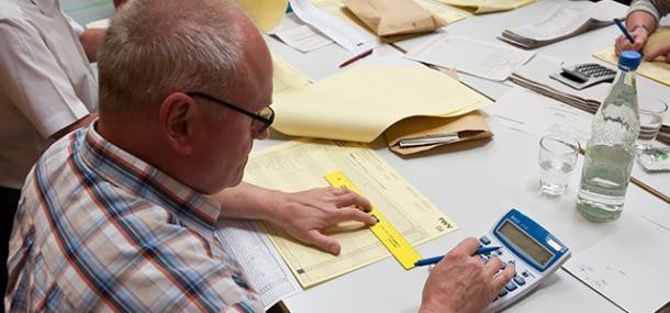 Wahlarchiv. (Foto: Rothe) Mann sitzt an einem Tisch und zählt Stimmen aus.
