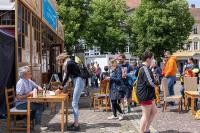 Marco Sonnleitner bei einer Signierstunde. Der Autor schreibt für „Die drei ???" und stellte bei den 28. Heidelberger Literaturtagen den Band „Der Fluch der Medusa" vor. (Foto: Buck) Foto von Menschen neben Spiegelzelt am Uniplatz