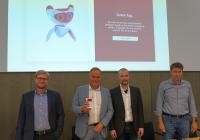 Vom Modell zum virtuellen Avatar: Oberbürgermeister Prof. Dr. Eckart Würzner präsentiert den ersten Prototypen des neuen virtuellen KI-Bürgerassistenten der Stadt Heidelberg zusammen mit Dr. Philipp Lechleiter (Amt für Digitales und Informationsverarbeitung), Jonas Andrulis (Gründer und CEO von Aleph Alpha) und Ralf Lüling (Aleph Alpha). (Foto: Stadt Heidelberg) Gruppenfoto mit Oberbürgermeister und virtuellem Assistent