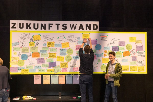 Enge Zusammenarbeit mit Bürgerinnen und Bürgern: Wünsche und Ideen für die Zukunft Heidelbergs wurden in verschiedenen Angeboten gesammelt. (Foto: Sabine Arndt) Zwei Menschen vor einer Stellwand mit Zetteln und der Aufschrift Zukunftswand.