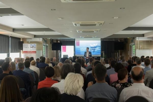 Marc Massoth, Leiter des Amtes für Wirtschaftsförderung und Wissenschaft, moderierte die Veranstaltung. (Foto: Sabine Arndt) Marc Massoth steht vor einem Publikum und spricht zu diesem.
