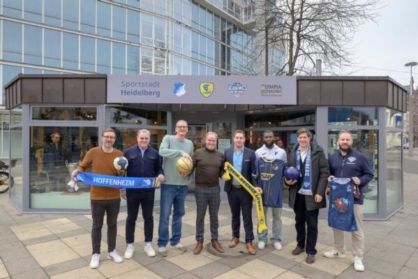 Freuten sich über die Eröffnung des neuen Sportpavillons (v.l.): Rüdiger Ofenloch, Pressesprecher Rhein-Neckar Löwen, Gert Bartmann, Leiter des Sportamtes, Daniel Strigel, Leiter des Olympiastützpunktes Rhein-Neckar, Oberbürgermeister Eckart Würzner, Tim Jost, Geschäftsführer TSG Hoffenheim, Ihlas Bebou, Spieler TSG Hoffenheim, Erster Bürgermeister Jürgen Odszuck, und Till Riedel, Geschäftsführer MLP Academics. Mitwirkende des Projekts und der Oberbürgermeister vor dem Sportpavillon