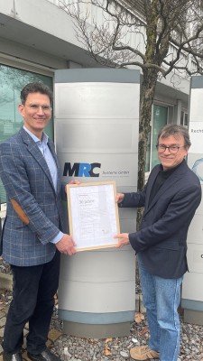 Marc Massoth (l.) überreicht Dr. Marcus Götz eine Urkunde zum 30-jährigen Bestehen. (Foto: Stadt Heidelberg) Zwei Männer stehen vor einer Stele. Einer der beiden übergibt dem anderen eine Urkunde in einem Rahmen.