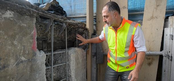 Voraussetzung für die Nutzung der Ziegelhäuser Brücke bis ins Jahr 2029 sind umfangreiche Sicherungs- und Überwachungsmaßnahmen. (Foto: Rothe) Ein Mann in Warnweste erklärt die Sicherheitsmängel und zeigt auf ein offenes Stück Mauerwerk.