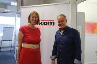 Links Natascha Hoffmeister, rechts Oberbürgermeister Eckart Würzner, im Hintergrund das Logo der Firma Sikom Software GmbH.
