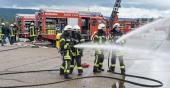 Vier Feuerwehrmänner spritzen mit einem Schlauch Wasser (Foto: Rothe)